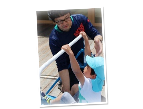 体育教室の様子。鉄棒をする男の子